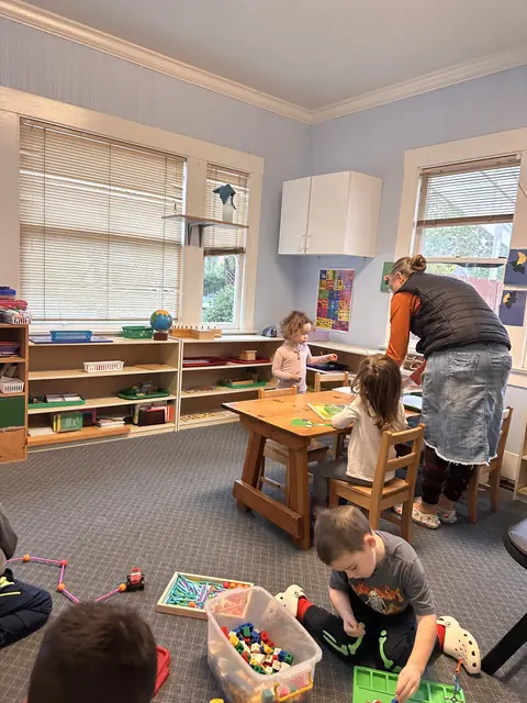 Children at work in the classroom with a teacher nearby
