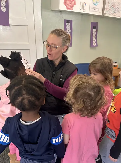 A teacher showing a book to a small group