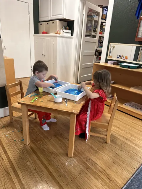 Two children painting at a table