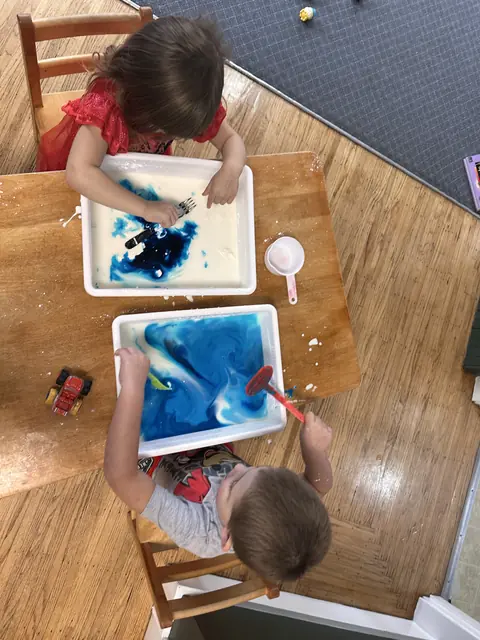 Overhead view of children working with water and colour
